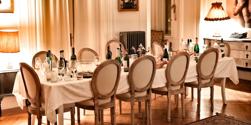 An image showing a restaurant interior with brown chairs placed next to dining tables.