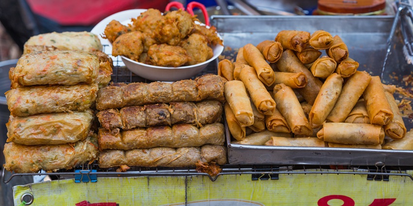 A picture of a street food vendor in Chinatown preparing delicious Thai dishes.