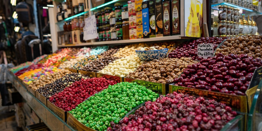 An image of the Turkish Grand Bazaar with busy shops with food.