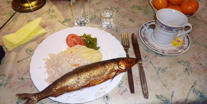 Cooked omul fish with white rice served in a restaurant near the deepest lake in Russia.