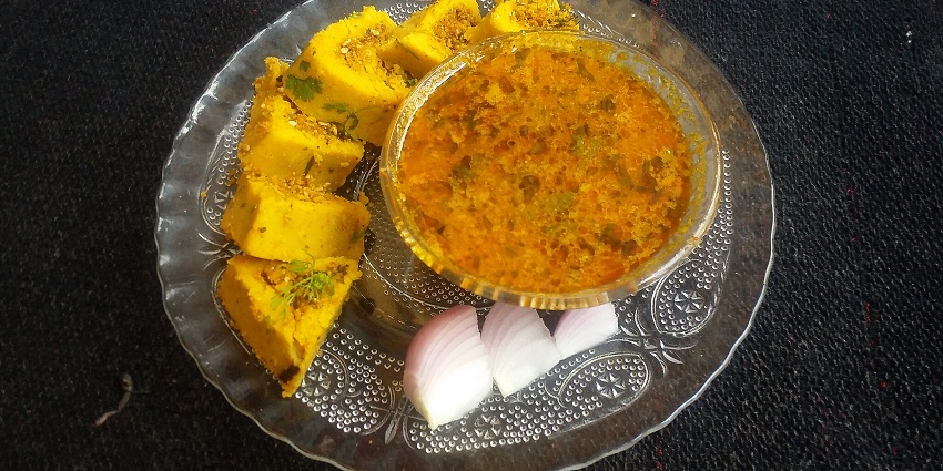 Indian dish with spicy curry, rolled flatbread, and sliced onions, dining options near Swaminarayan temple.