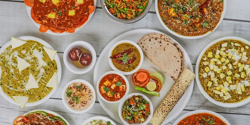 A colourful spread of traditional Indian dishes on a table, showcasing vibrant spices and ingredients.