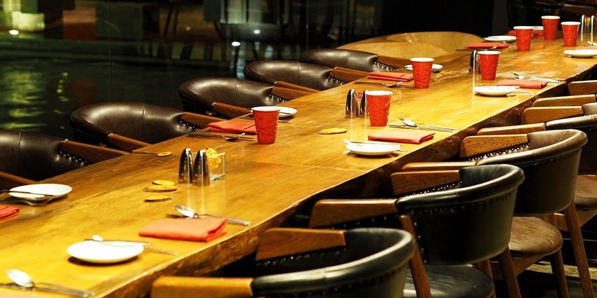 An image showing a restaurant dining area with a set dining table and chairs