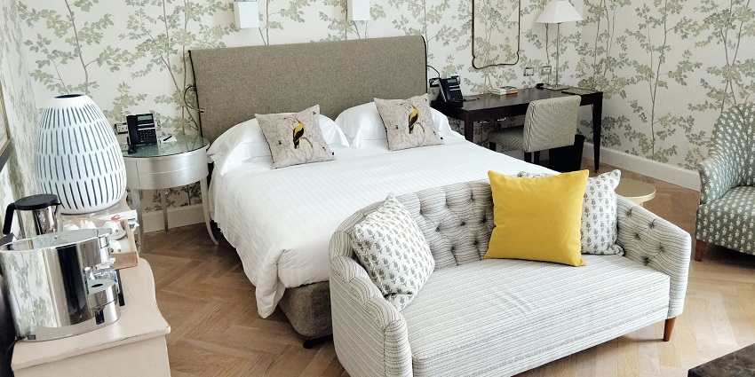 An image of an accommodation with neatly made bed and neat setting with utilities