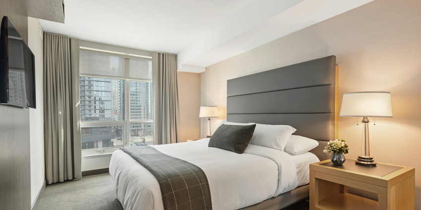 Modern hotel room with city view, elegant decor, and cozy lighting for a comfortable stay