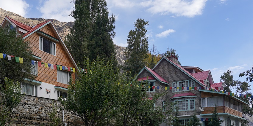 Multiple hotel residences and homestays with flags, stone pavements, stairs and trees