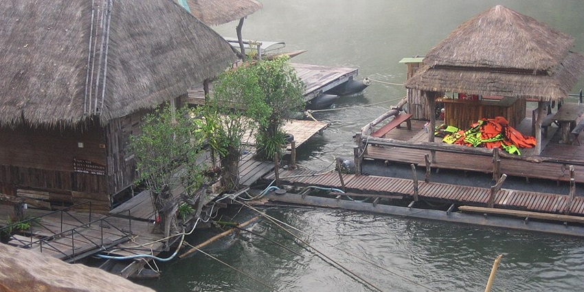 Floating hotel on the River Kwai with rooms, river access, and morning fog in Kanchanaburi