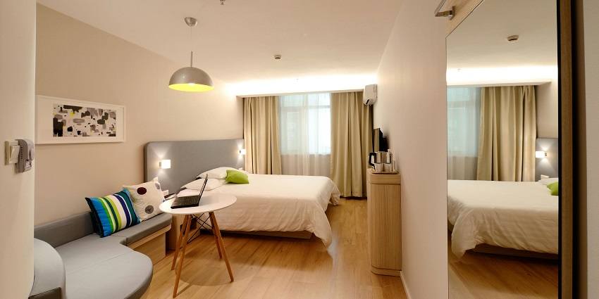 A lavish executive suite room with a view of a river from a glass window.
