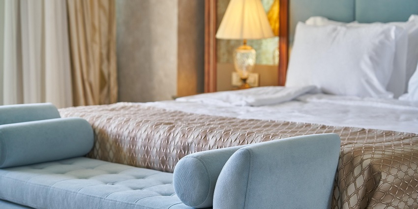An image showing a hotel bedroom with elegant decor, a large bed, and ambient lighting.