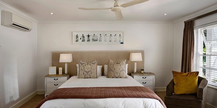 An image showing a hotel bedroom with stylish decor, accent lighting, and spacious layout.