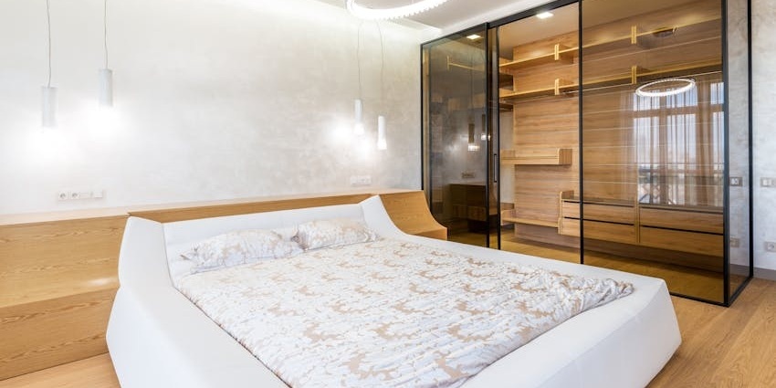 Stylish bedroom featuring chic furniture, neutral tones, and soft ambient lighting.