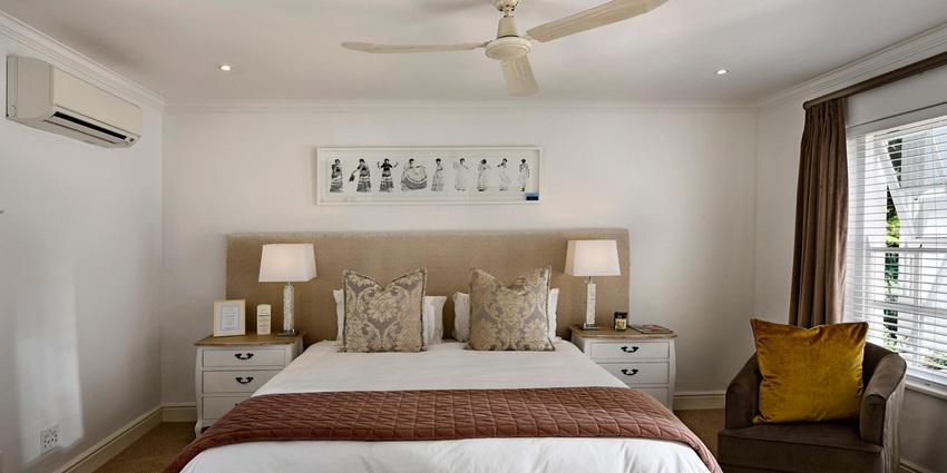An image showing a stylish hotel room with a bed and thoughtfully arranged décor.