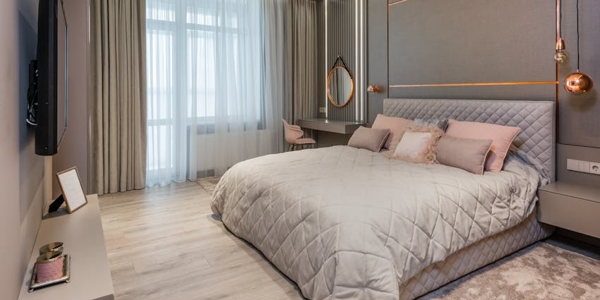 A warm-toned luxury hotel room with soft lighting and plush bedding, near Sukhothai Historical Park.