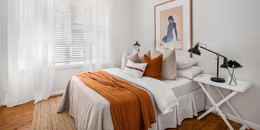 An image showing a hotel bedroom with modern furnishings and refined interior design.