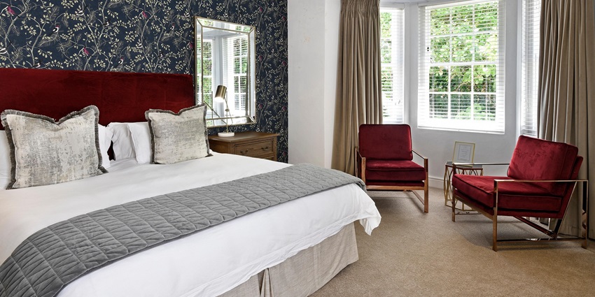 Image of a hotel bedroom with modern furniture, a large bed, and interior design details.