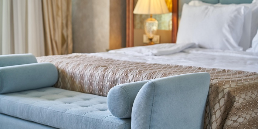 An image showing a bedroom featuring a bed, a window, and high-end furniture arrangements.