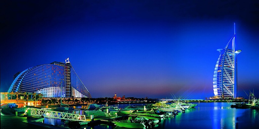 Night view of Dubai's iconic Burj Al Arab and Jumeirah Beach Hotel, against the skyline
