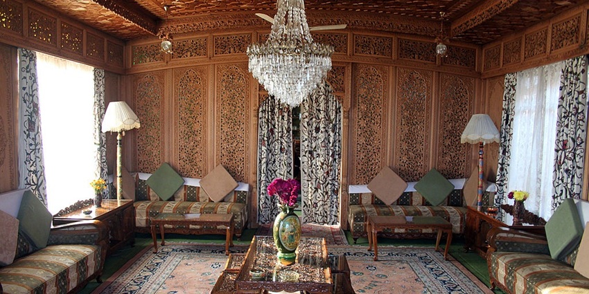 Interior of houseboat with a flower pot on a table, two lamps and unique curtains