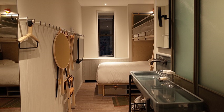 A small and cosy hotel room with modern amenities and a wall-mounted LED TV.