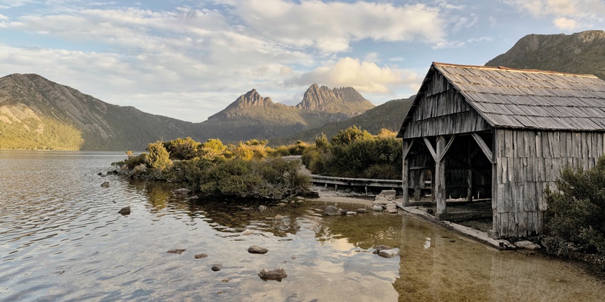 A picture of a cosy lodge near Cradle Mountain, surrounded by misty forests.