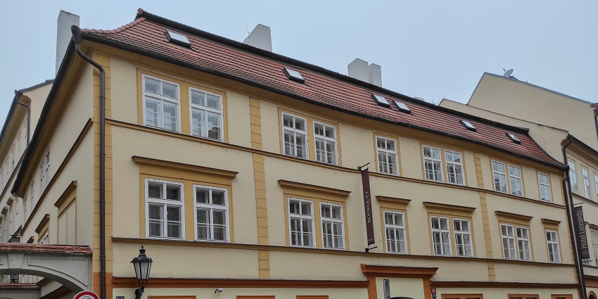 A hotel in Prague is standing in a narrow street, showcasing historic architecture