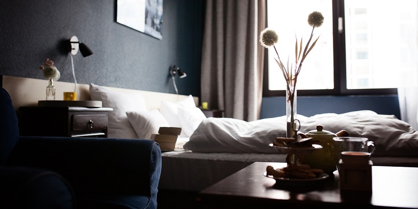 An image showing a cozy hotel room with a bed and modern furnishings resembling the stays near Spencer Plaza