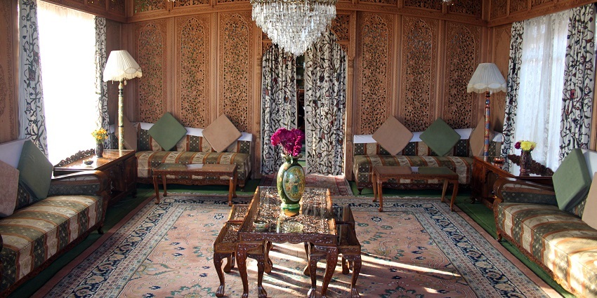 Interior of houseboat with a flower pot on a table, two lamps on each side and curtains