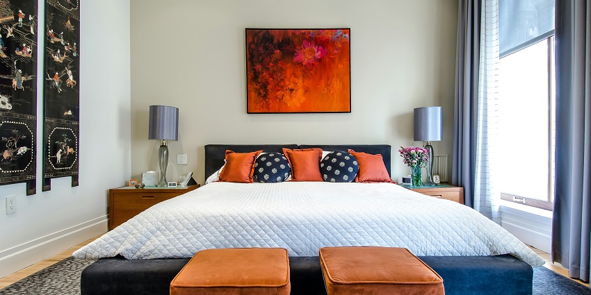 An image of a well maintained hotel room with a king size bed and a picture on the wall