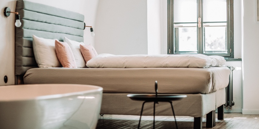 A modern bedroom with natural lighting, featuring minimalist decor near Bhudargad Fort.