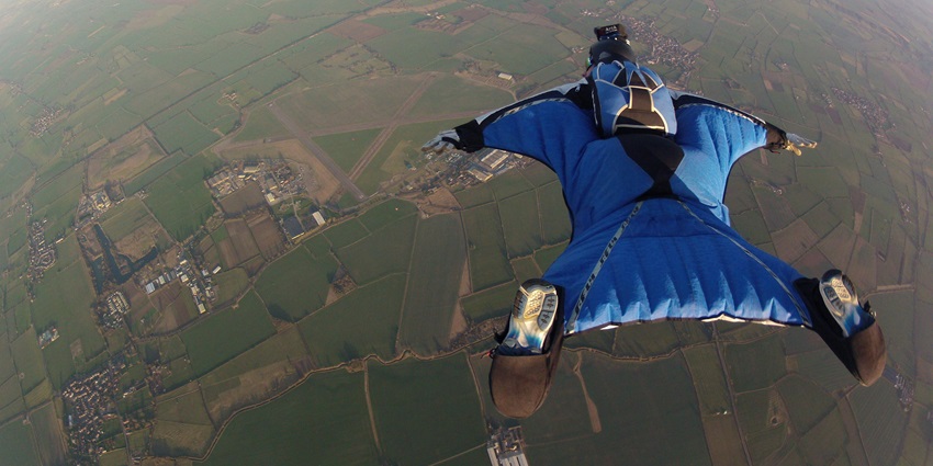An image of a skydiver in wingsuit soaring over East Midlands, captured mid-air with Camera