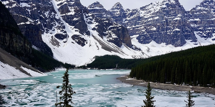Moraine Lake in Banff National Park, with water flowing and mountains covered in snow