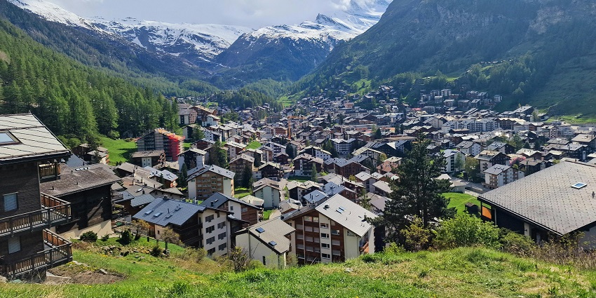 Scenic view of the buildings in Zermatt surrounded by lush greenery and forests