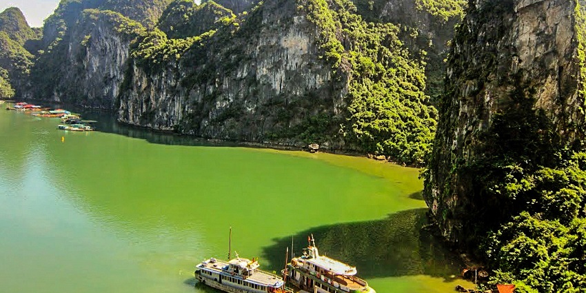 A scenic view of Ba Be Lake, passing through rolling green hills and local villages