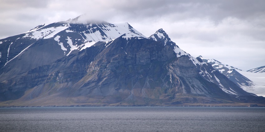 Alkhornet mountain peak rising above tundra landscape in Oscar II Land, Svalbard, one of the best places to visit on the Svalbard islands.