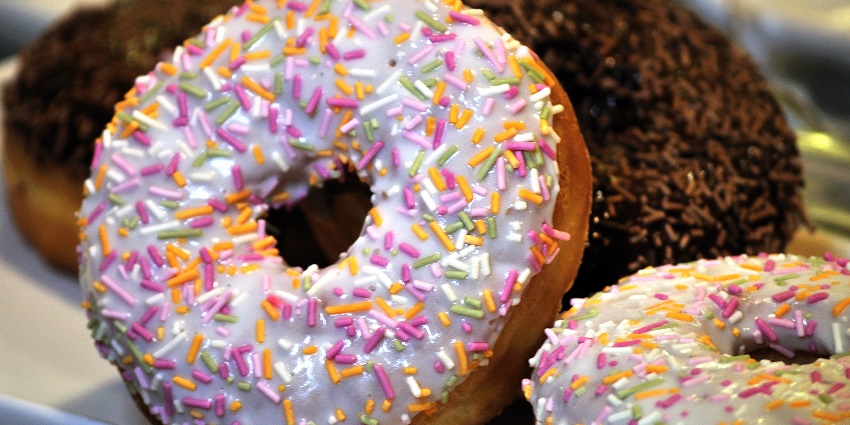 Doughnuts with colourful sprinkles, stacked together and looking vibrant and delicious