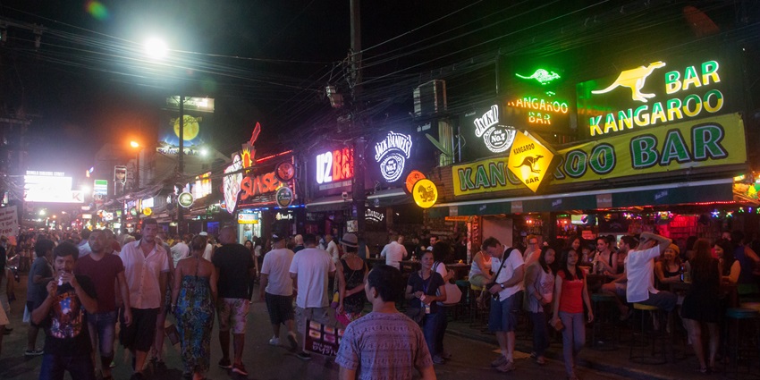 A picture of a bustling street in Thailand with a number of bars and restaurants
