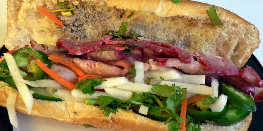 Vietnamese and French-flavoured bánh mì sandwich filled with pickled veggies, herbs, and grilled meat