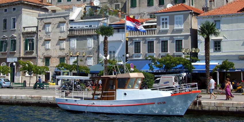 An image showing the harbour of Sibenik with boats and historic buildings along the waterfront.