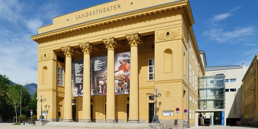 Elegant exterior of Innsbruck State Theatre with a softly ambience for a winter performance, one of the best things to see in Innsbruck in winter.