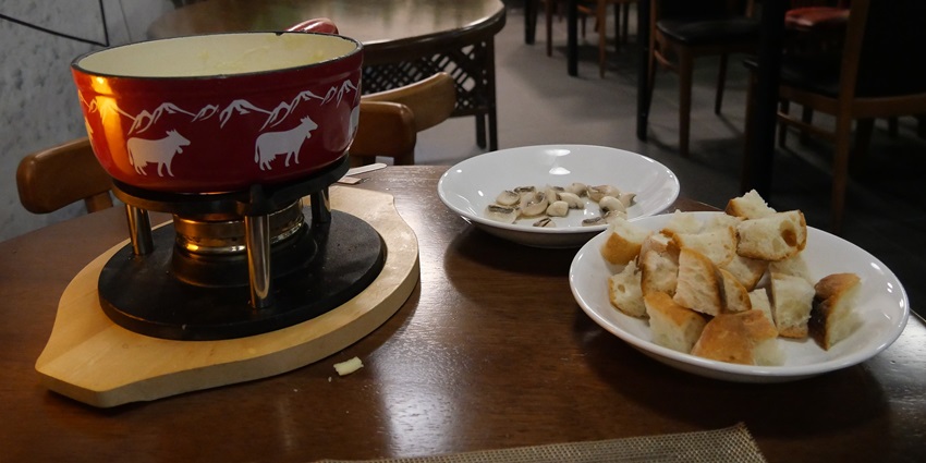 An image showing cheese fondue in bread, a famous food in Switzerland, served warm.