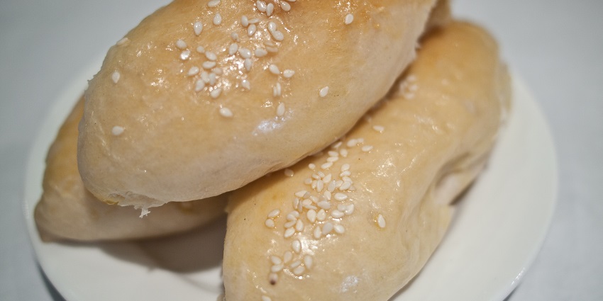 A triplet of Dim Sum Coconut flavoured Buns with an exotic topping is served at a restaurant.