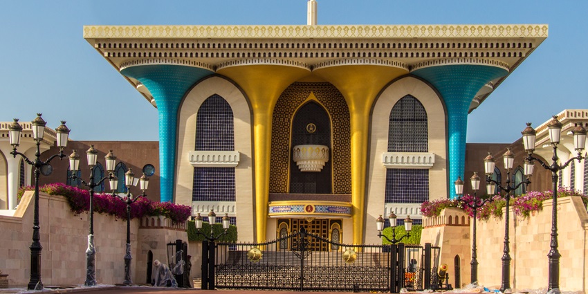 Al Alam Palace lit at night showcasing its blue and gold facade in Old Muscat, Oman