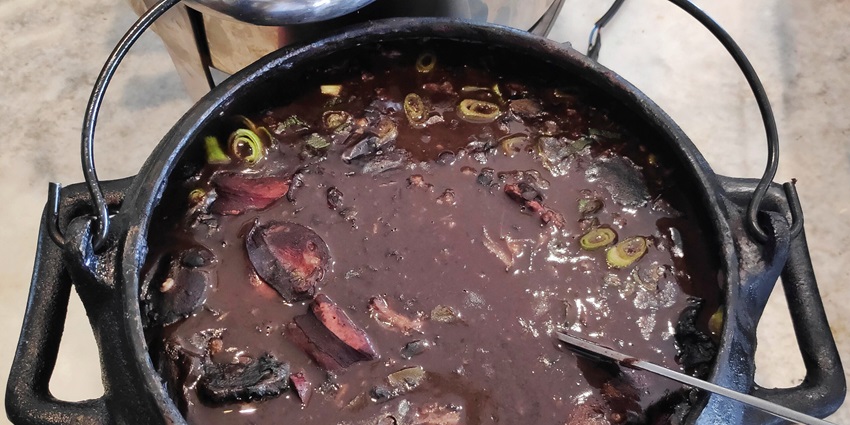 A delicious bowl of feijoada, the must-try famous food in Brazil, in the restaurant.