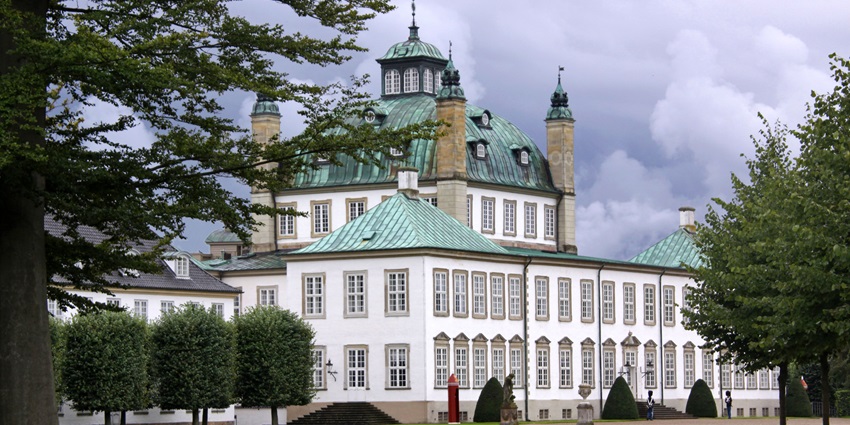 The iconic Fredensborg Palace seen from the garden, highlighting its Baroque design.