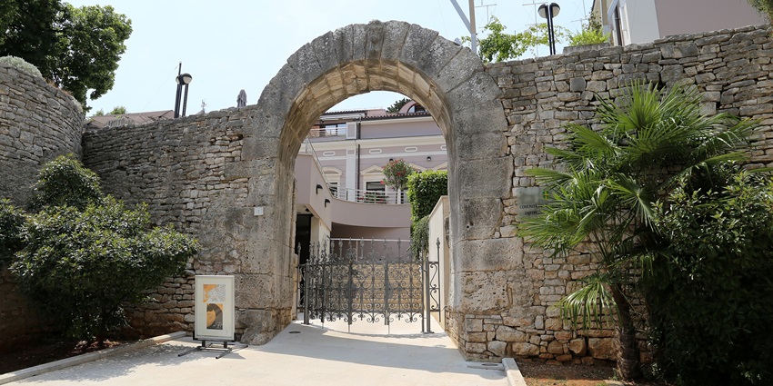 Ancient stone Gate of Hercules with historic carvings and weathered arches.