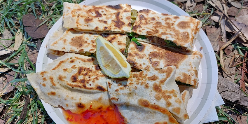 Turkish gözleme with lemon placed in the centre and a dipping sauce served on the side