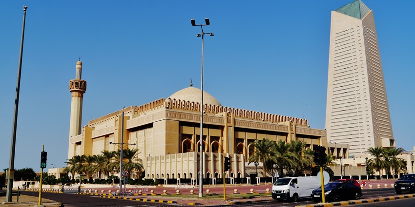 South facade of Kuwait’s Grand Mosque with dome and minaret under clear sky.