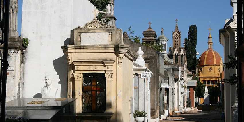 Marble mausoleums and shadowy walkways in Recoleta Cemetery, with gothic architecture, one of the best things to do in Buenos Aires.