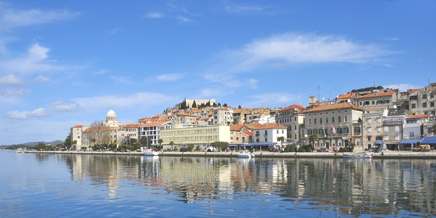 An image showing a view of Sibenik, highlighting its architecture and coastal surroundings.