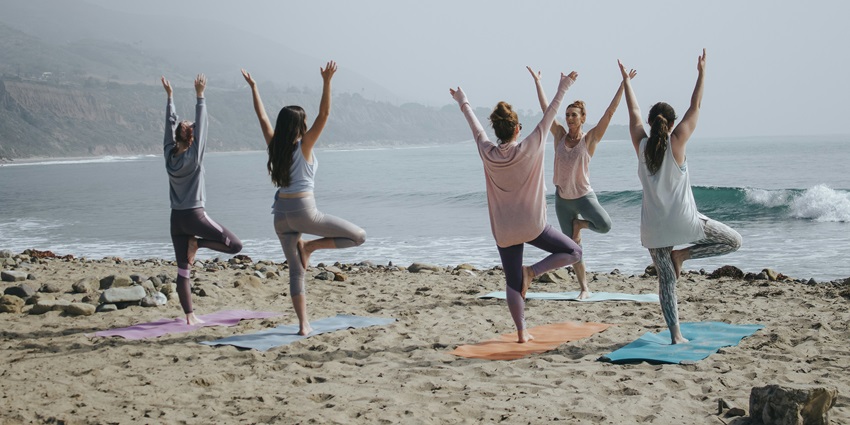 Group yoga session on sandy shore – things to do at the Copacabana Beach